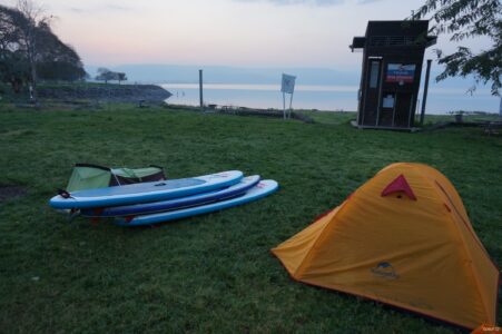 Sleeping on a beach with paddleboards next to us Tent on beach of a lake