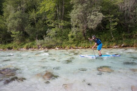 Soca River in Slovenia near Bovec Fast-paddling SUP rider