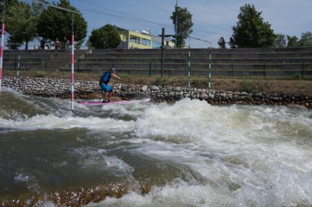 SUP paddler riding slalom on whitewater