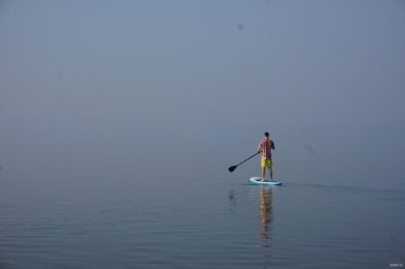 Guy on SUP - nothing around SUP rider in fog on lake
