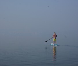 SUP rider in fog on lake