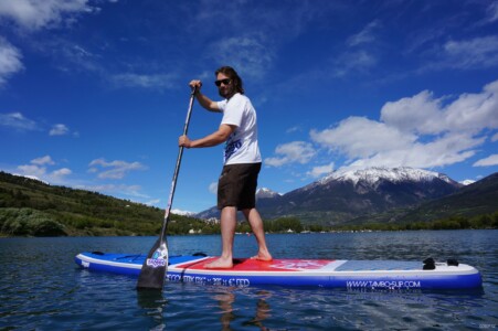 Man standing on SUP under the French Alps