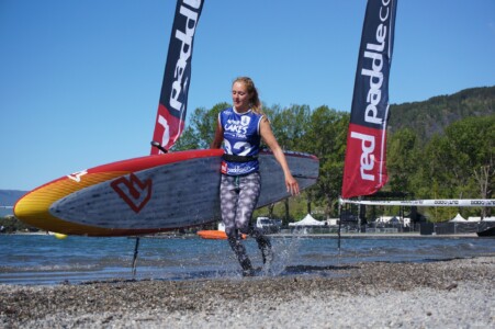 Girl running with a paddleboard during a race