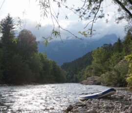 Paddleboard under mountains in clouds