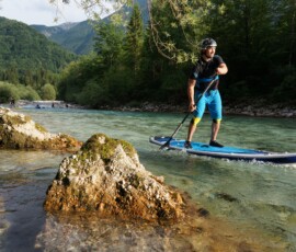 SUP paddler on crystal-clear river