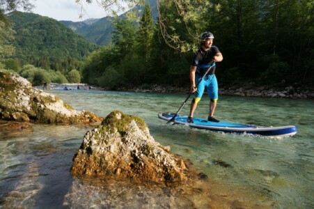 SUP paddler on crystal-clear river