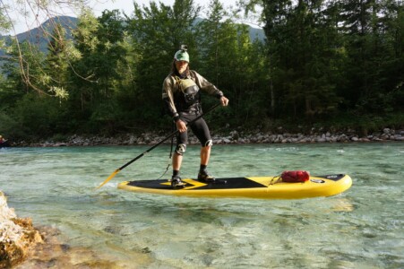 Rider on a yellow SUP on Soca River with gopro on