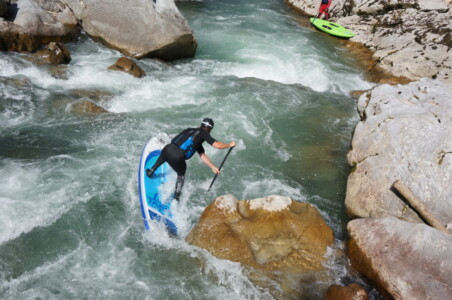 SUP whitewater rider leaning on paddle