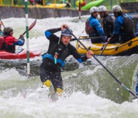 Paddleboardista splouvá umělý kanál vedle raftu