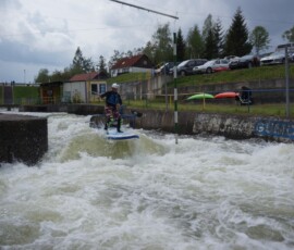 Překonávání stupu s paddleboardem na divoké vodě.